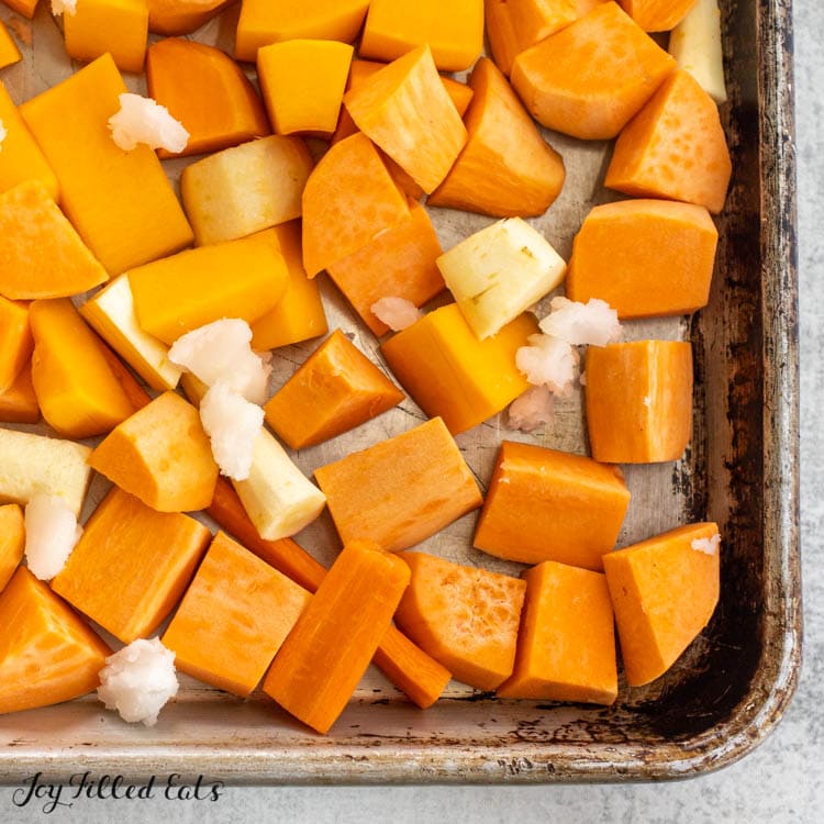 raw sweet potatoes, parsnips, and butternut squash on tray