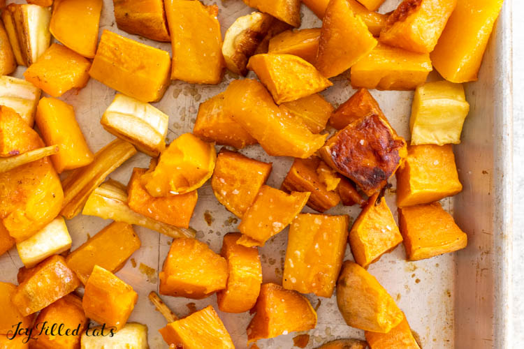 close up on baked sweet potatoes, parsnips, and butternut squash on tray