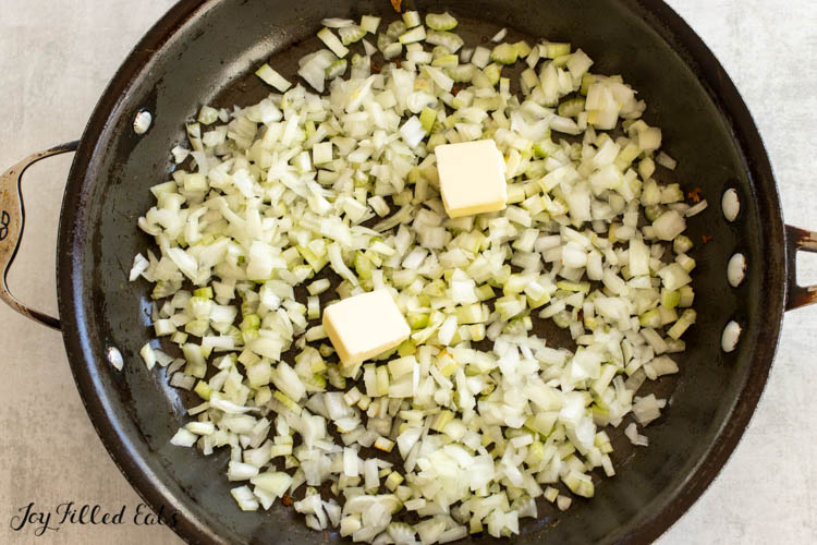 butter in pan with raw onion and celery