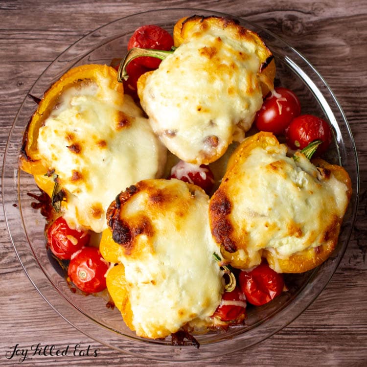 overhead view of white lasagna stuffed peppers with cherry tomatoes