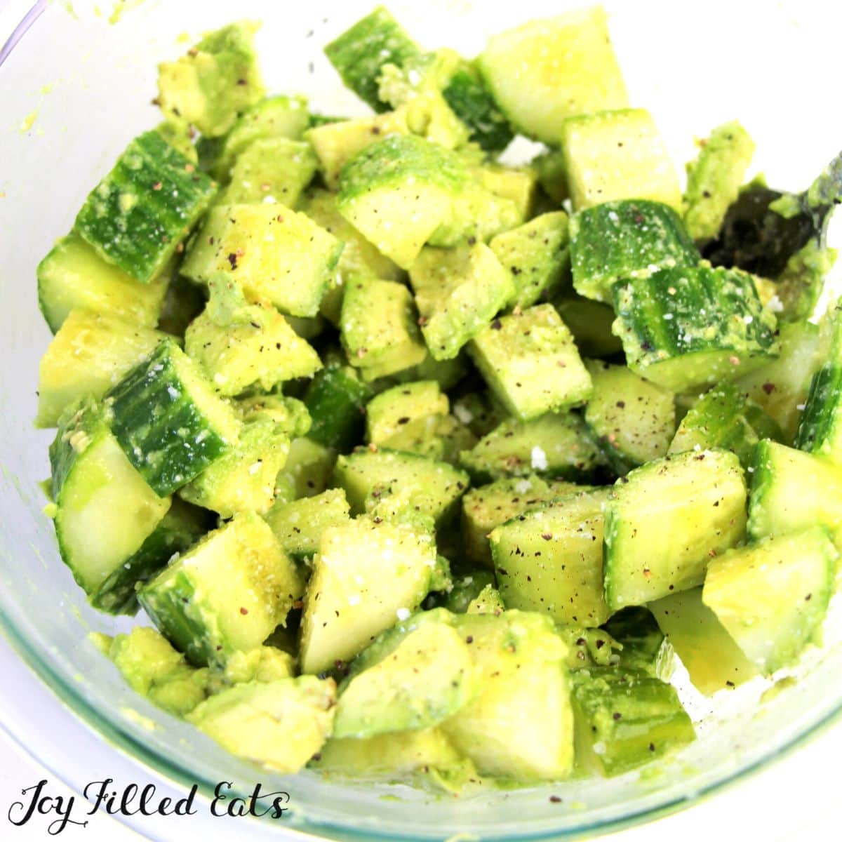 cucumber avocado salad seasoned in a mixing bowl