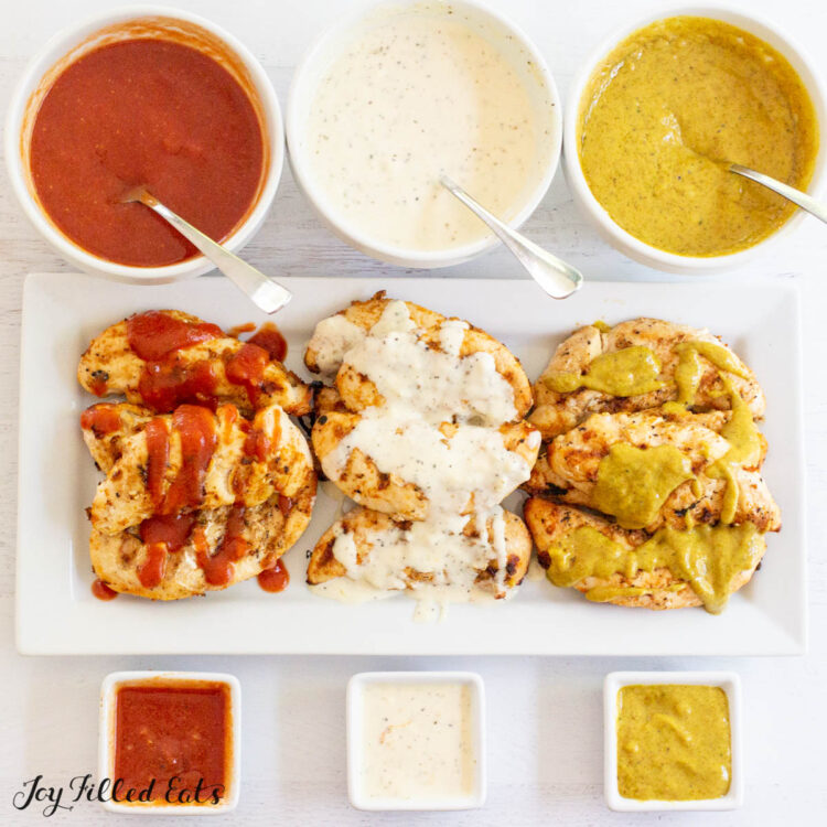 3 bowls of keto barbecue sauce with 3 different flavors: keto white bbq sauce, keto mustard bbq sauce, and a ketchup based low carb bbq sauce