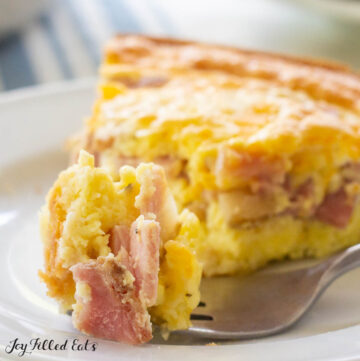 close up of a bite of keto quiche with ham and cheese on a fork