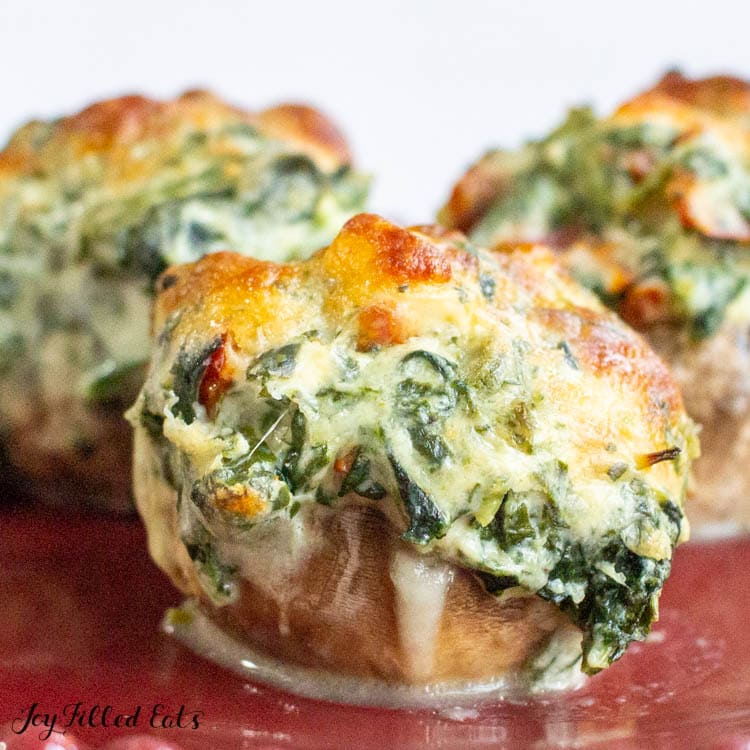 three keto stuffed mushrooms with spinach on a plate