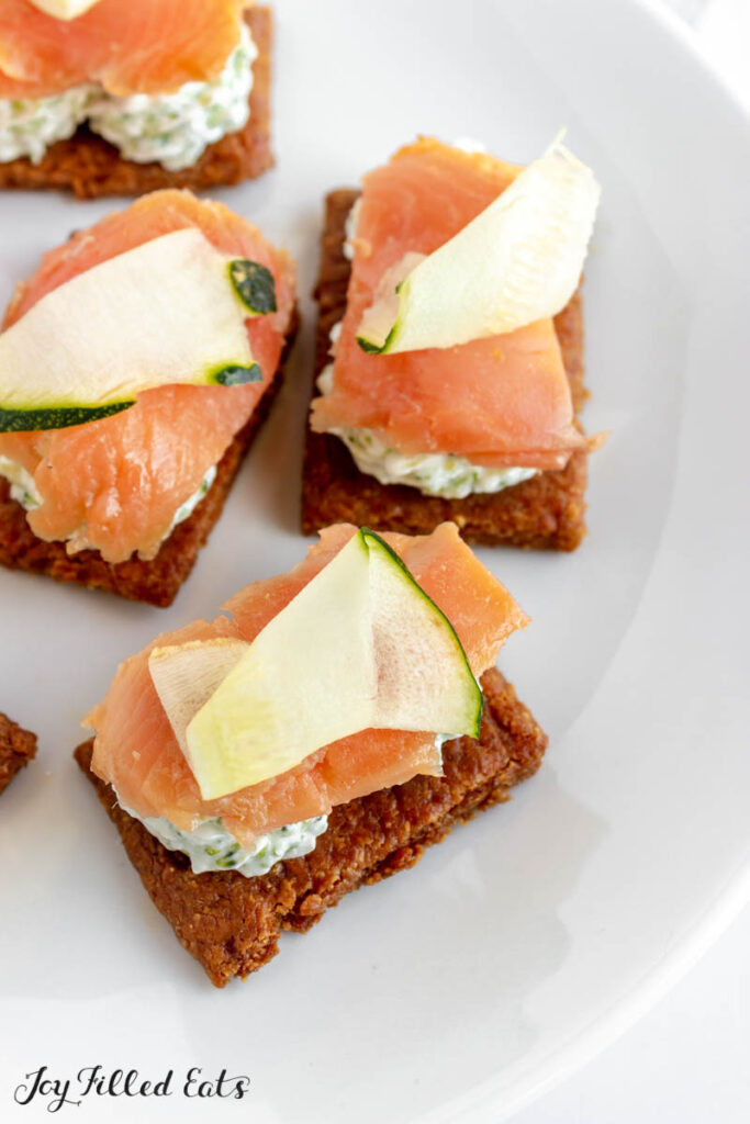 close up of zucchini and smoked salmon on keto crackers
