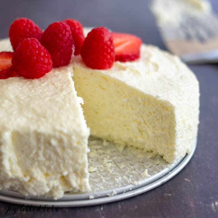 mascarpone cheesecake topped with berries and slice missing close up 