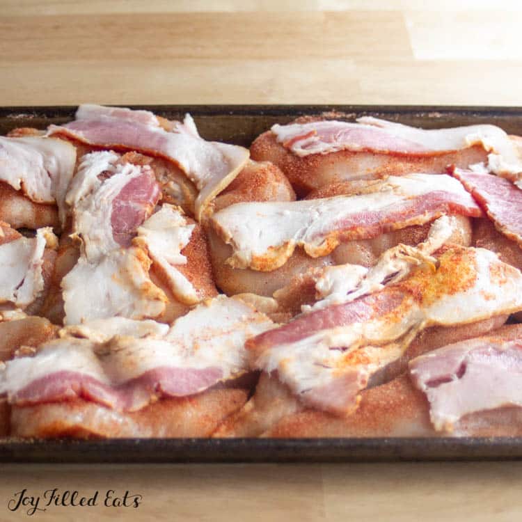 bacon on top of raw chicken