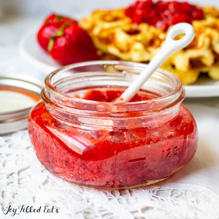 jar of sugar free strawberry jam in front of keto waffles 