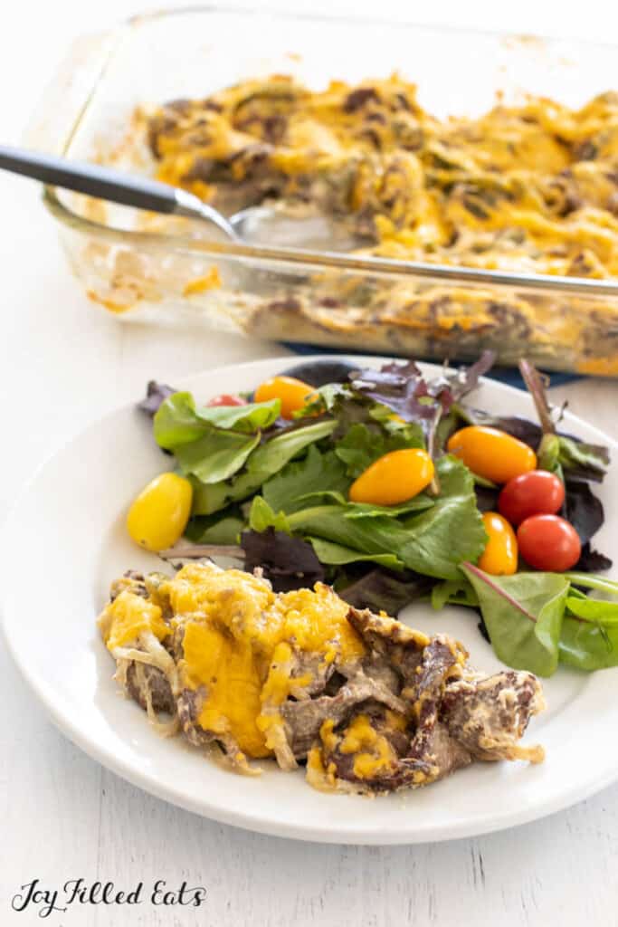 serving of low carb philly cheesesteak casserole recipe on plate with salad