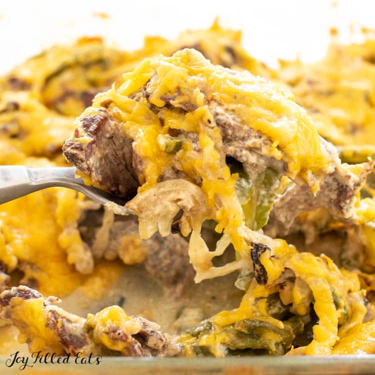 spoon lifting some low carb philly cheesesteak casserole recipe out of the baking dish