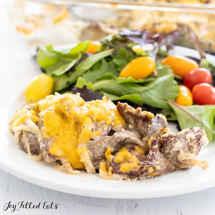 serving of low carb philly cheesesteak casserole recipe on a plate with salad