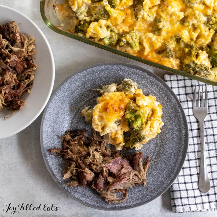 overhead shot of keto broccoli cauliflower casserole on a plate with pulled pork