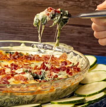 keto spinach dip recipe being scooped from pie plate with serving knife