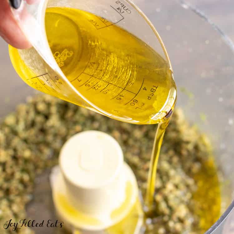extra virgin olive oil being poured into food processor