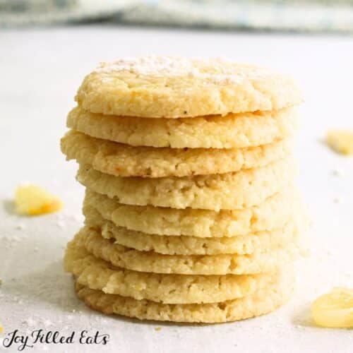 keto lemon cookies in a stack with slices of lemon around them