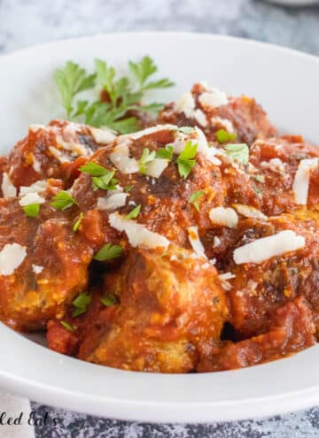 pork sausage meatball recipe shown with marinara sauce and parmesan cheese in bowl