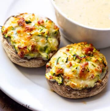Bacon and Cheese Stuffed Mushrooms served on a plate with a bowl of soup
