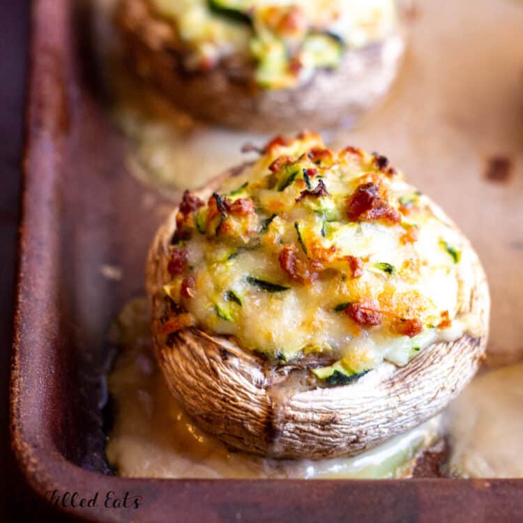 close up on Bacon and Cheese Stuffed Mushrooms on baking sheet