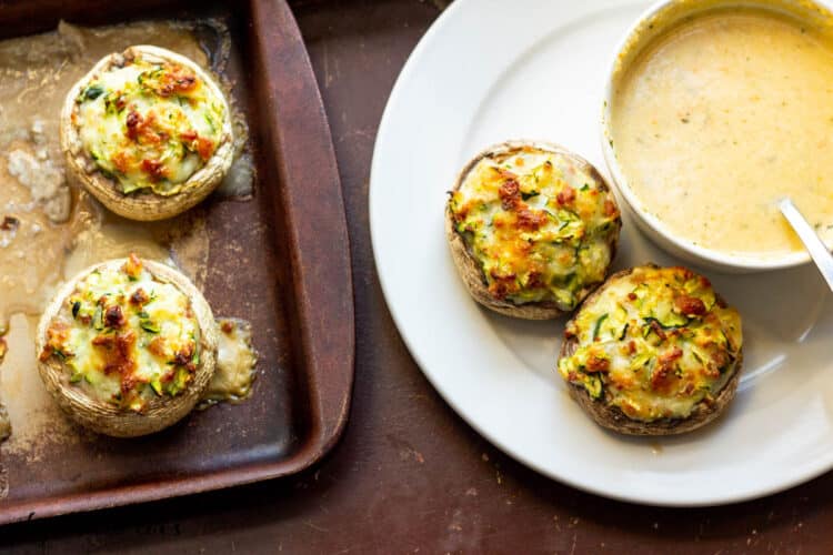 Bacon and Cheese Stuffed Mushrooms served on a plate with soup and shown on baking dish