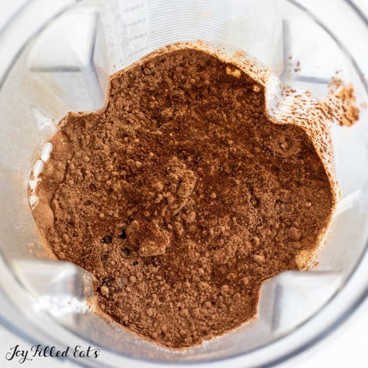cocoa powder and instant coffee on top of liquid in blender