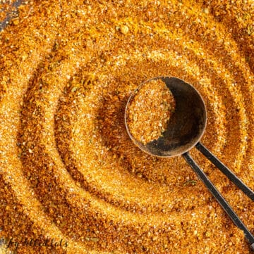 chermoula spice blend shown with measuring spoon resting in swirled powder