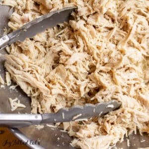 instant pot shredded chicken breast in bowl with tongs