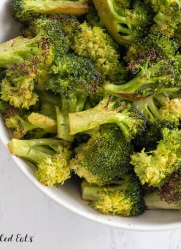 broiled broccoli recipe shown close up in serving bowl