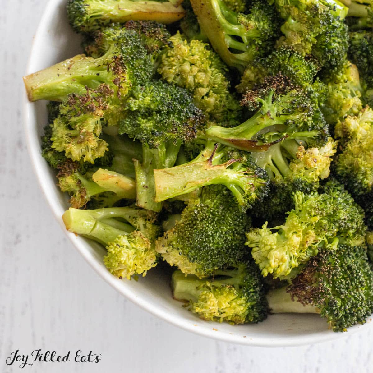 broiled broccoli recipe shown close up in serving bowl