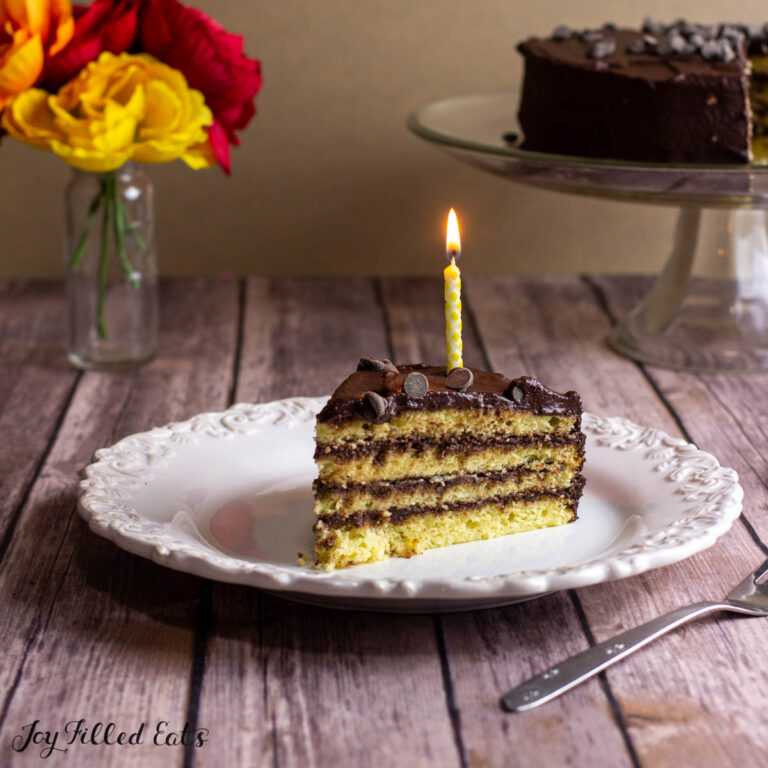 keto birthday cake slice on a plate with a candle