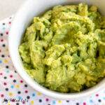 4 ingredient guacamole recipe in bowl on polka dot napkin close up