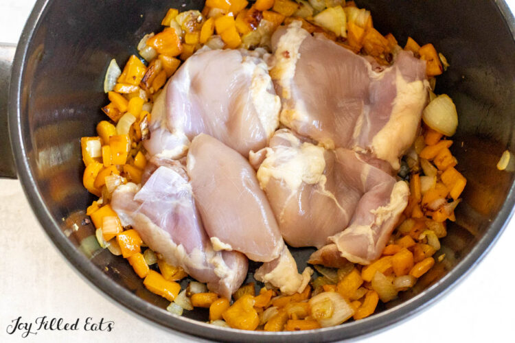 raw chicken thighs added to pot