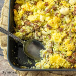 keto sausage stuffing recipe in casserole dish with spoon close up