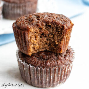 chocolate protein muffins with top muffin missing a bite and napkin behind