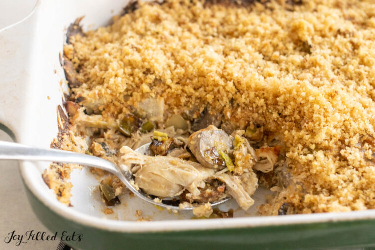 spoon resting in casserole dish with chicken leek mushroom casserole
