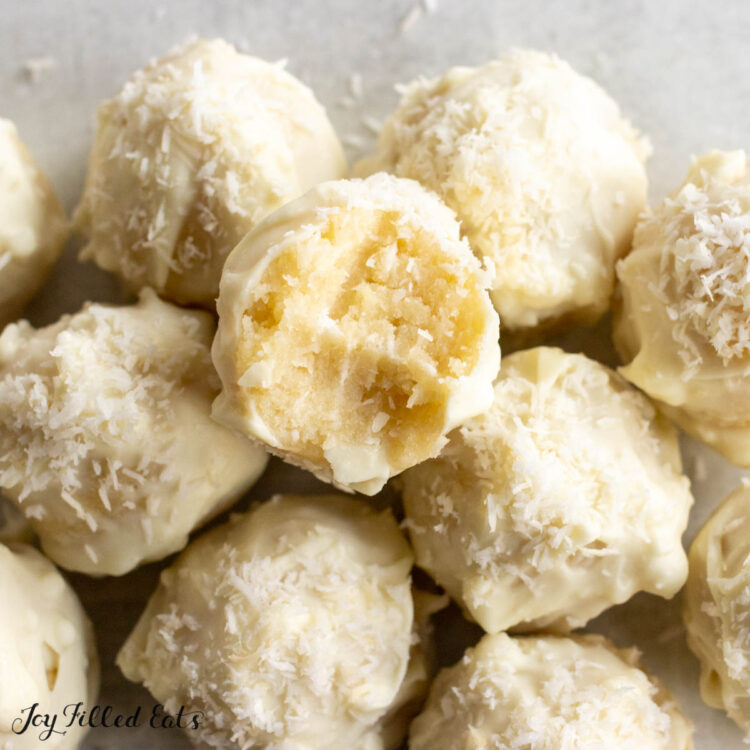 coconut cream truffles in a pile close up with top candy missing a bite