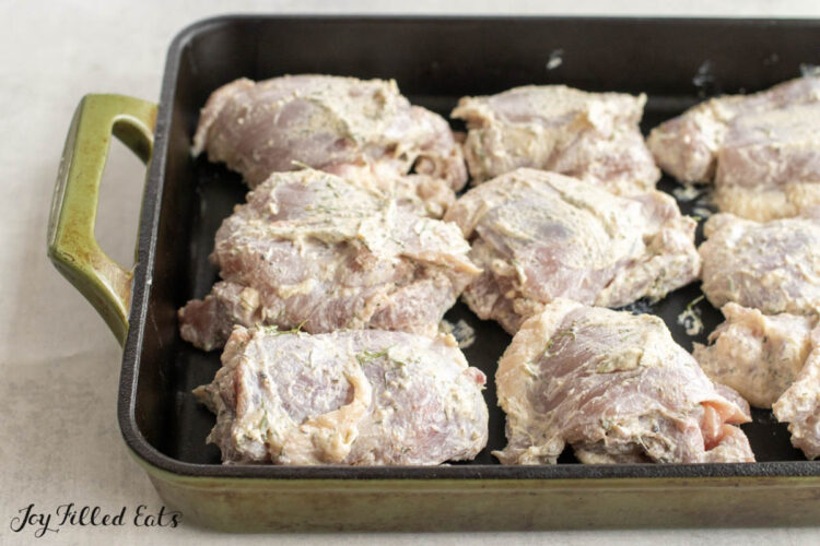 coated chicken thighs in pan