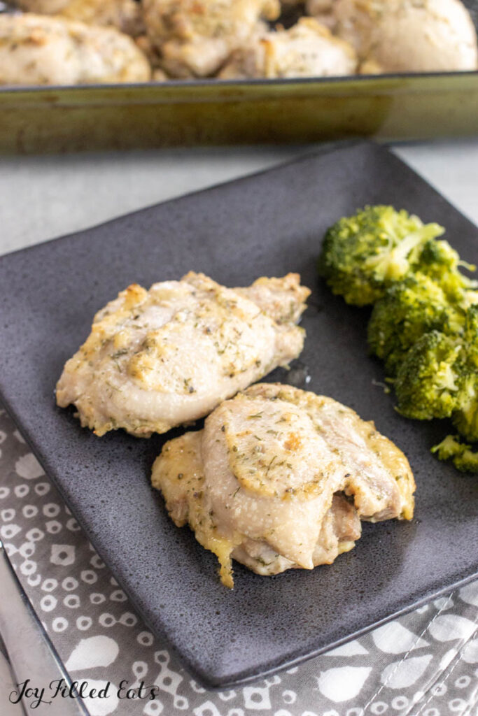 ranch chicken thighs on dinner plate with side of broccoli