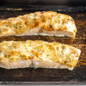 baked salmon with mayonnaise close up on stoneware baking dish