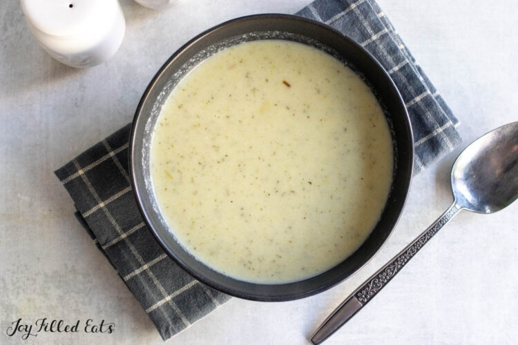 cauliflower leek soup in bowl with spoon on the side