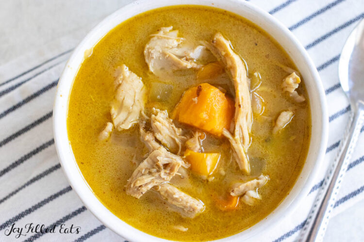 dairy free creamy chicken soup in white bowl close up