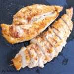 butter poached chicken breasts with one sliced