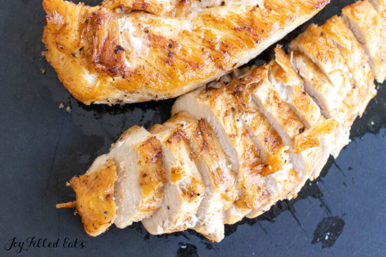 sliced butter poached chicken on a cutting board