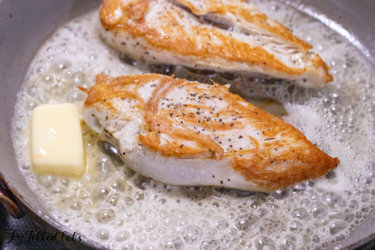 butter melting in pan next to chicken