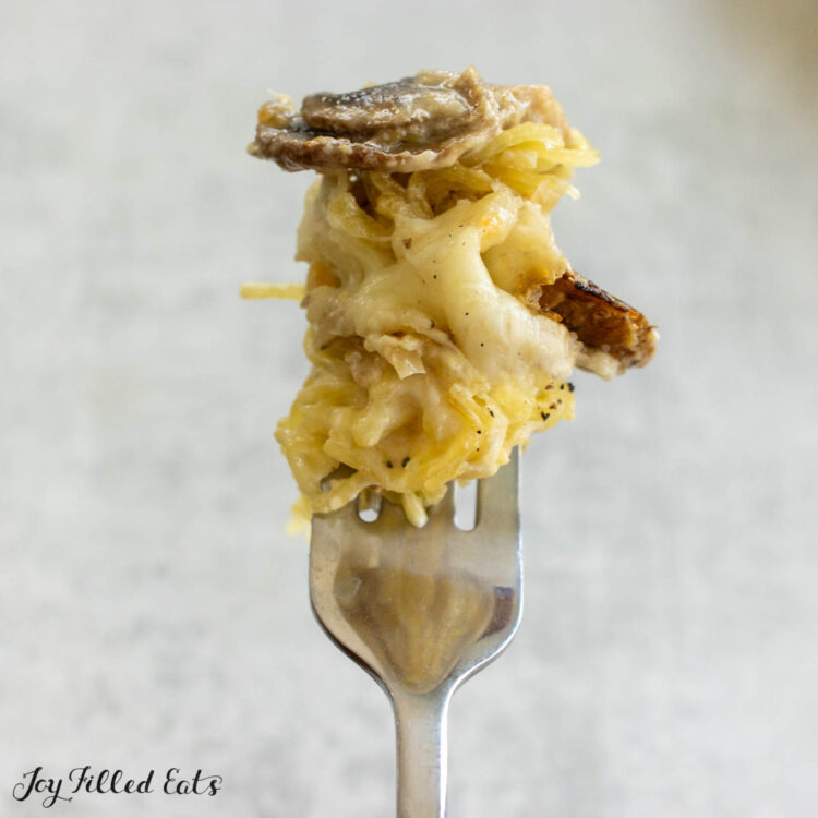 bite of chicken tetrazzini casserole held up on a fork