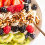 3-ingredient coconut pecan granola close up on yogurt with berries and kiwi slices