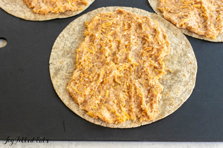 ground meat spread out on a tortilla
