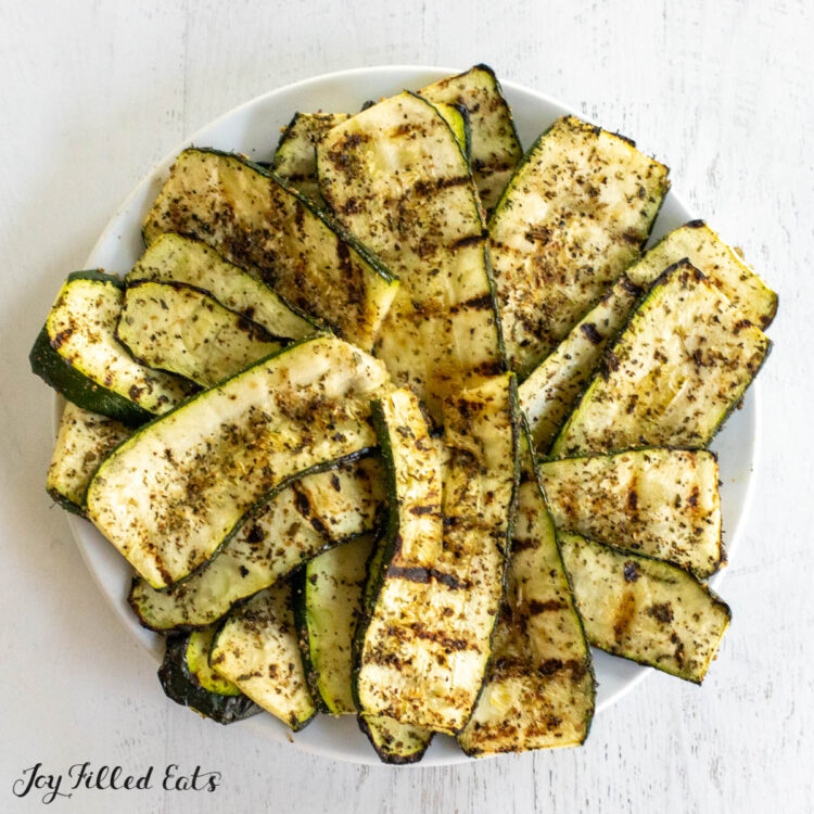 grilled zucchini with greek seasoning on white plate