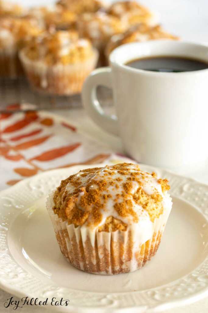 keto cinnamon muffin on plate with coffee behind
