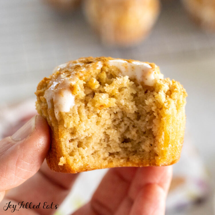 hand holding up one of the keto cinnamon muffins missing a bite