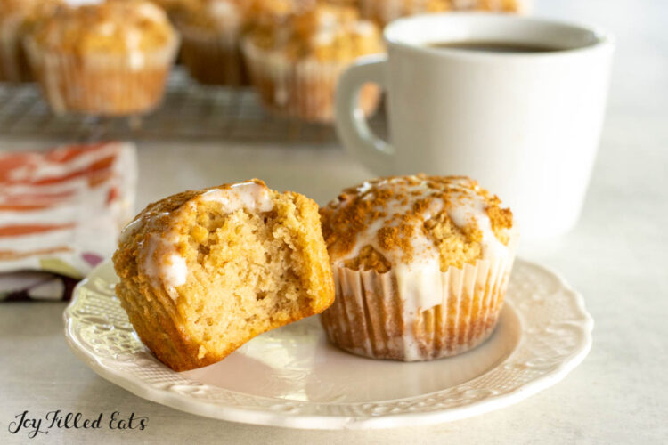 two keto cinnamon muffins on a small plate with one missing a bite